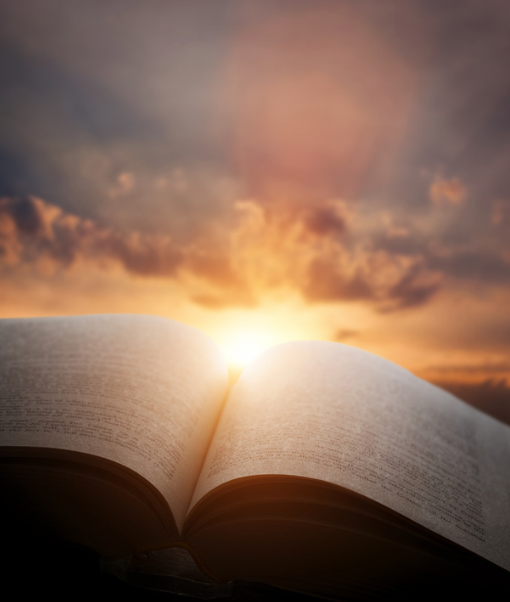 image of an open bible with a sunrise in the background (510 x 602 px)